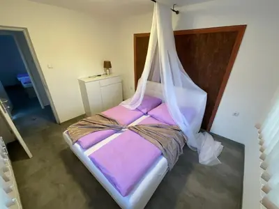 a bedroom with a bed with a mosquito net at Arena 2 in Ripač