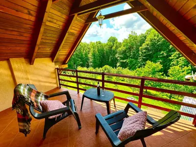 a screened in porch with chairs and a table at Foresta Home in Gradačac