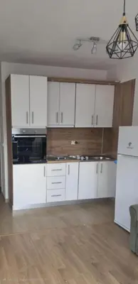 a kitchen with white cabinets and a white refrigerator at Apartman LAVANDA in Teslić