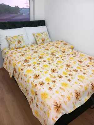 a bed with a bedspread with bees on it at Apartman LAVANDA in Teslić