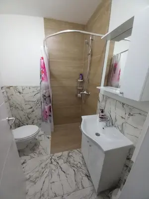 a white bathroom with a sink and a toilet at Apartman LAVANDA in Teslić