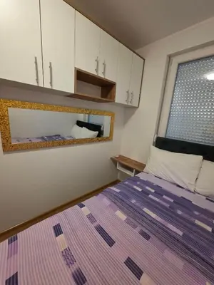 a small bedroom with a bed and a window at Apartman LAVANDA in Teslić