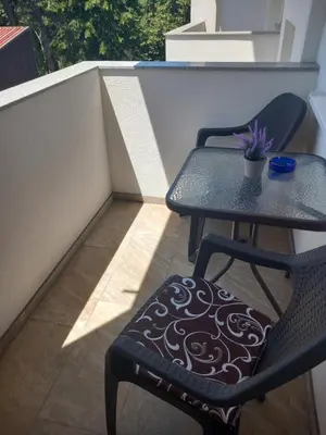 a table and a chair on a balcony at Apartman LAVANDA in Teslić