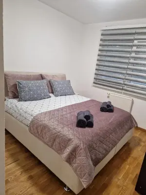 a bedroom with a bed with two hats on it at Apartman 3 Tuzla in Tuzla