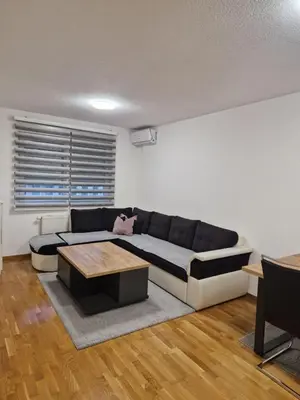 a living room with a couch and a table at Apartman 3 Tuzla in Tuzla