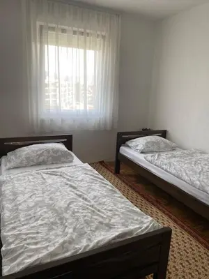 two beds in a room with a window at Apartman Fad in Bihać