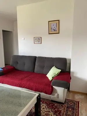 a living room with a couch with a red blanket at Apartman Fad in Bihać