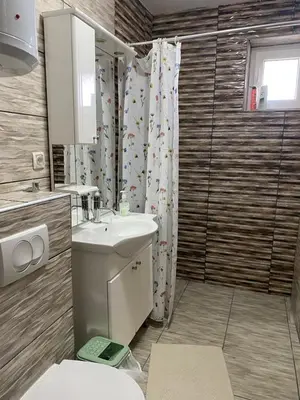 a bathroom with a sink and a toilet and a shower at Apartman Fad in Bihać