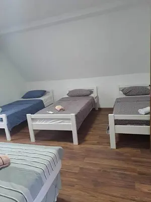 three beds in a room with wooden floors at Kuća za odmor Noah in Bihać