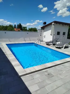 a swimming pool with blue water in a yard at Kuća za odmor Noah in Bihać