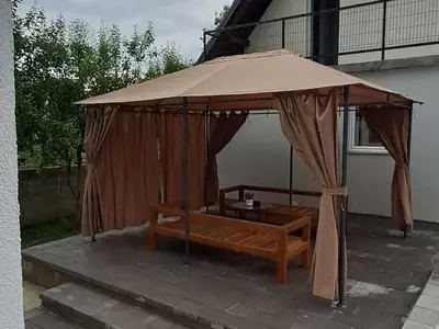a gazebo with a table and a bench under it at Kuća za odmor Noah in Bihać