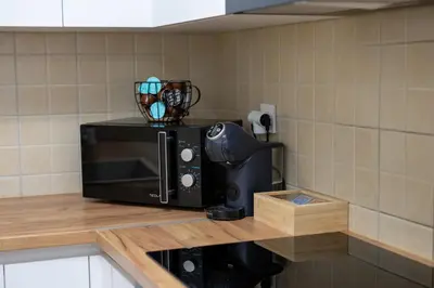 a microwave sitting on top of a kitchen counter at Aurum apartman Žepče in Žepče