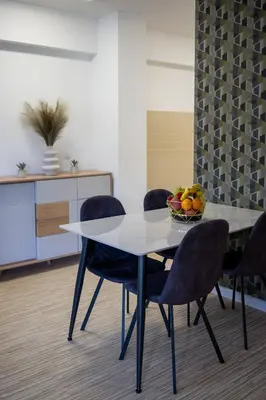 a table with chairs and a bowl of fruit on it at Aurum apartman Žepče in Žepče