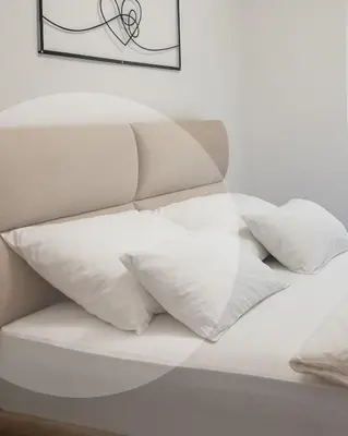 a white bed with white pillows on it at Aurum apartman Žepče in Žepče