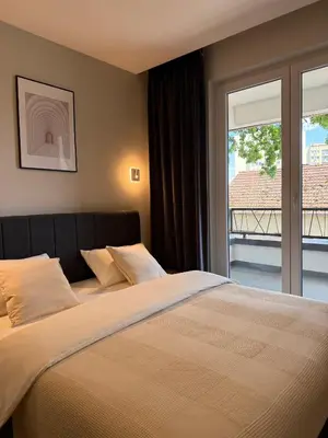 a bedroom with a large bed with a large window at Stari Hrast Apartmani in Bosanska Gradiška
