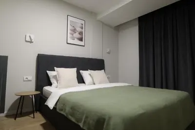 a bedroom with a large bed with white pillows at Stari Hrast Apartmani in Bosanska Gradiška