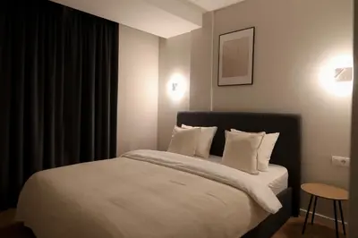 a bedroom with a large bed with white sheets and pillows at Stari Hrast Apartmani in Bosanska Gradiška
