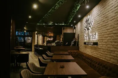 a restaurant with wooden tables and chairs and a brick wall at Stari Hrast Apartmani in Bosanska Gradiška