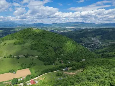 an aerial view of a green hill with trees at Home of Peace at the top of the Pyramid Sun and Love in Visoko