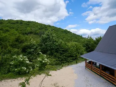 a house on a beach next to a mountain at Home of Peace at the top of the Pyramid Sun and Love in Visoko