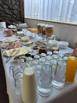 a table with glasses of milk and other food at Prenoćište Stanica in Bosanska Krupa
