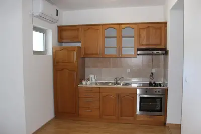 a kitchen with wooden cabinets and a sink at Prenoćište Stanica in Bosanska Krupa