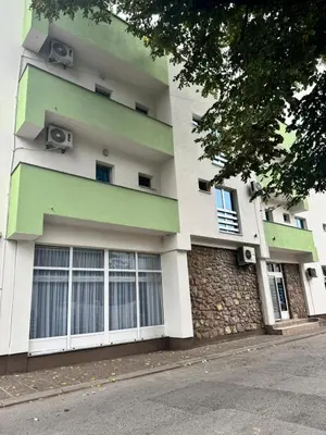 a green and white building with windows at Prenoćište Stanica in Bosanska Krupa