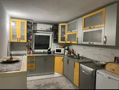 a kitchen with gray and yellow cabinets and appliances at Peace Holiday Home in Bihać