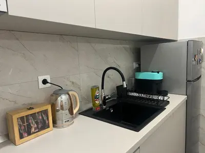 a kitchen counter with a sink and a coffee maker at Lumière Apartment in Banja Luka