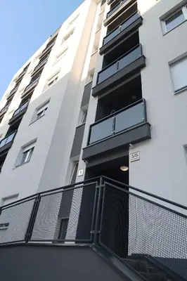 a tall white building with black balconies at Lumière Apartment in Banja Luka