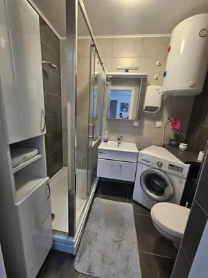 a bathroom with a shower sink and a washing machine at Apartment STELLA in Bihać