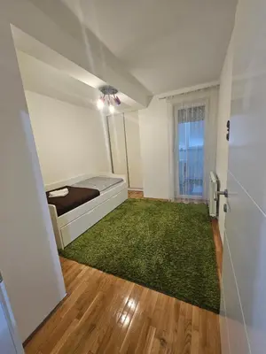a bedroom with a bed and a green rug at Apartment STELLA in Bihać