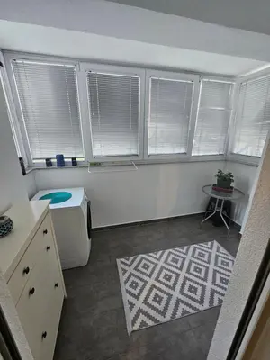 a small room with windows and a rug at Apartment STELLA in Bihać