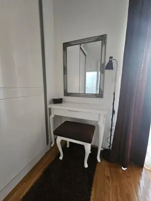 a white dressing table with a mirror and a stool at Apartment STELLA in Bihać