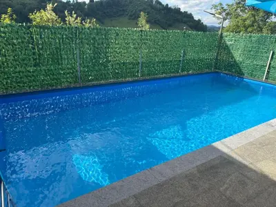 a swimming pool with blue water in front of a fence at AM Pyramid resting in Visoko