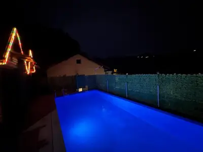 a swimming pool lit up in blue at night at AM Pyramid resting in Visoko