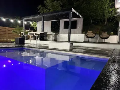 a swimming pool in front of a house at night at Elmo Oasis in Banovići