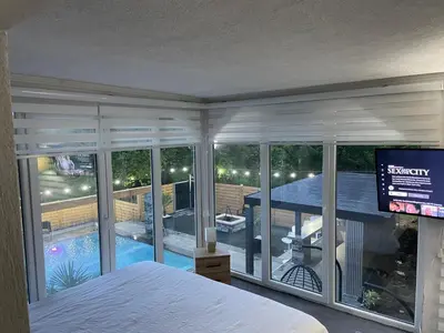 a bedroom with a view of a pool and a television at Elmo Oasis in Banovići