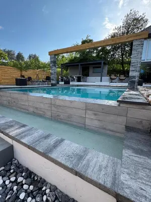 a swimming pool with a stone wall around it at Elmo Oasis in Banovići