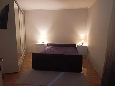 a bedroom with a bed and two lights on two tables at CityComfort Tuzla in Tuzla