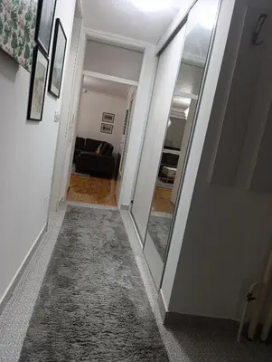 a hallway with a mirror and a living room at CityComfort Tuzla in Tuzla