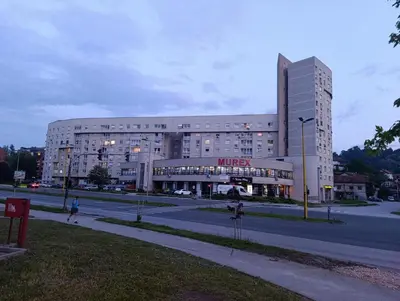 a large white building with a sign on it at CityComfort Tuzla in Tuzla