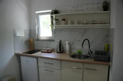 a small kitchen with a sink and a window at Studio apartman Ivica in Jajce