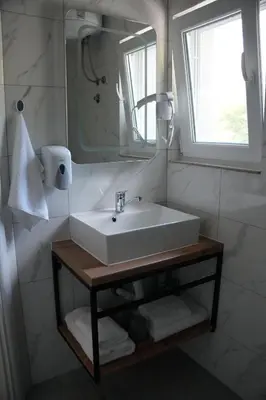 a bathroom with a white sink and a mirror at Studio apartman Ivica in Jajce