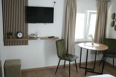 a living room with a table and a tv on the wall at Studio apartman Ivica in Jajce