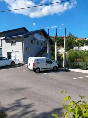 a white van parked in a parking lot in front of a building at Studio apartman Ivica in Jajce