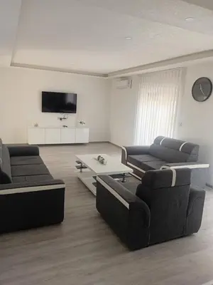 a living room with two couches and a flat screen tv at Apartman Volijak 44 in Jajce