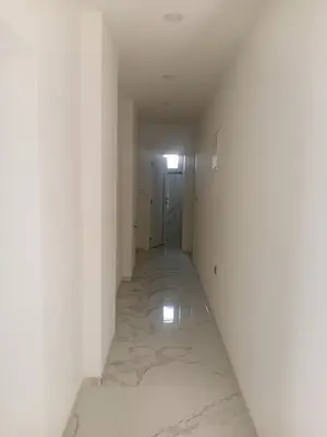 an empty hallway with white walls and marble floors at Apartman Volijak 44 in Jajce