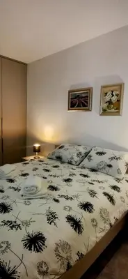 a bedroom with a bed with a black and white comforter at Apartman Bonaca in Kiseljak