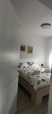 a bedroom with a bed in a white room at Apartman Bonaca in Kiseljak